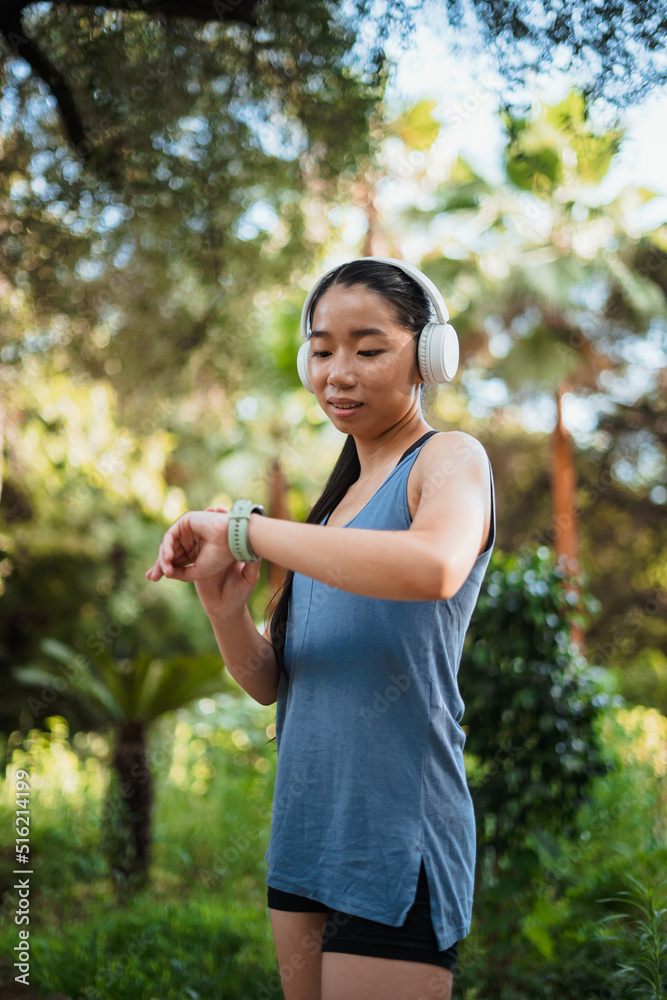 Fitness teenager checking her heartbeat on her smart watch after jogging in the park Fitness teenager checking her heartbeat on her smart watch after jogging in the park