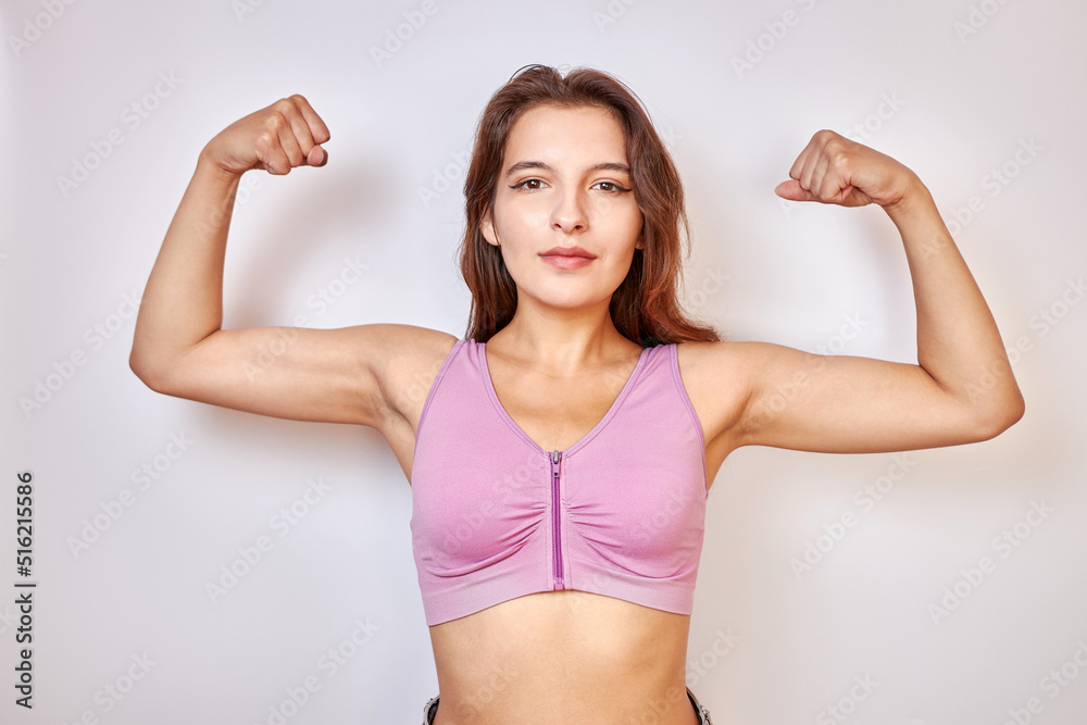A beautiful girl raised her hands and strained her biceps. The concept of fitness. A beautiful girl raised her hands and strained her biceps. The concept of fitness.