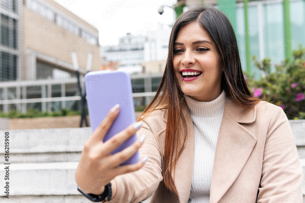 a Latin young adult woman with glasses is surprised while looking at the phone a Latin young adult woman with glasses is surprised while looking at the phone