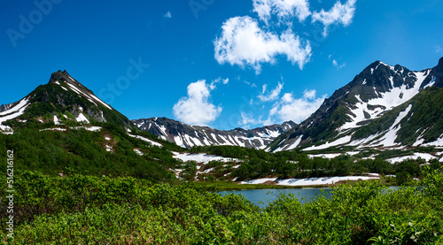 Russia, Kamchatka. Ancient volcano Vachkazets. Panoramic mountain range against a background of blue sky and clouds. photo