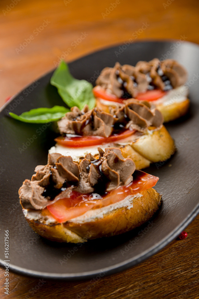 Bruschetta with chicken pate and caramelized onion with cheese and tomatoes