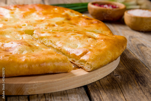 Ossetian pie with cabbage on old wooden table