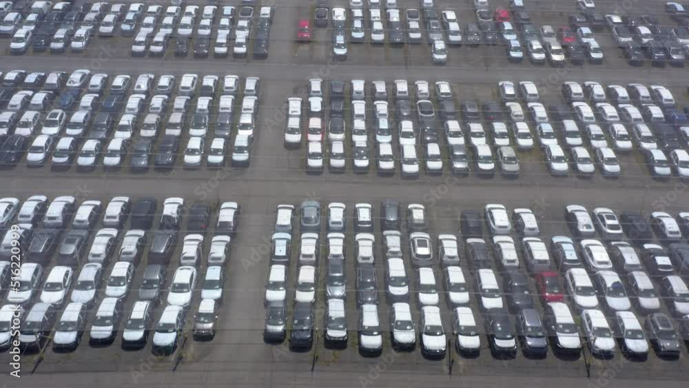 Aerial top view of many cars parked. Aerial shot above a parking area full of cars. multicolored cars on warehouse parking lot. Dealership car lot. 