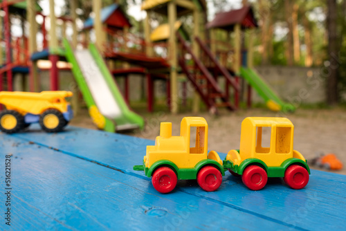 A toy plastic truck of bright colors on the playground