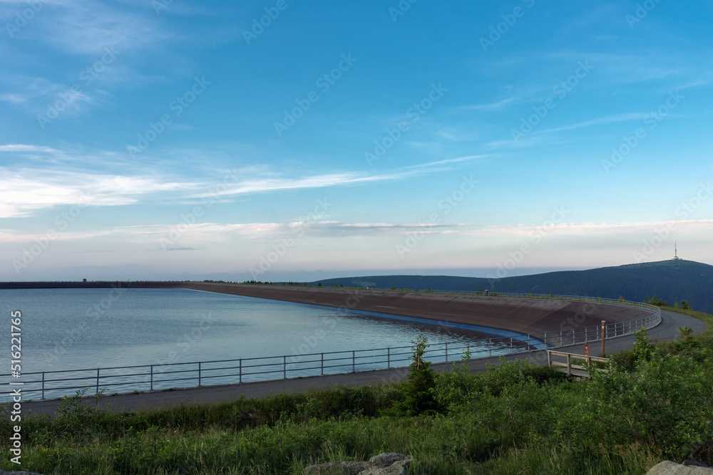 Upper water reservoir of the pumped storage hydro power plant Dlouhe Strane in Jeseniky Mountains, Czech Republic. Summer sunset  with blue sky and clouds.
