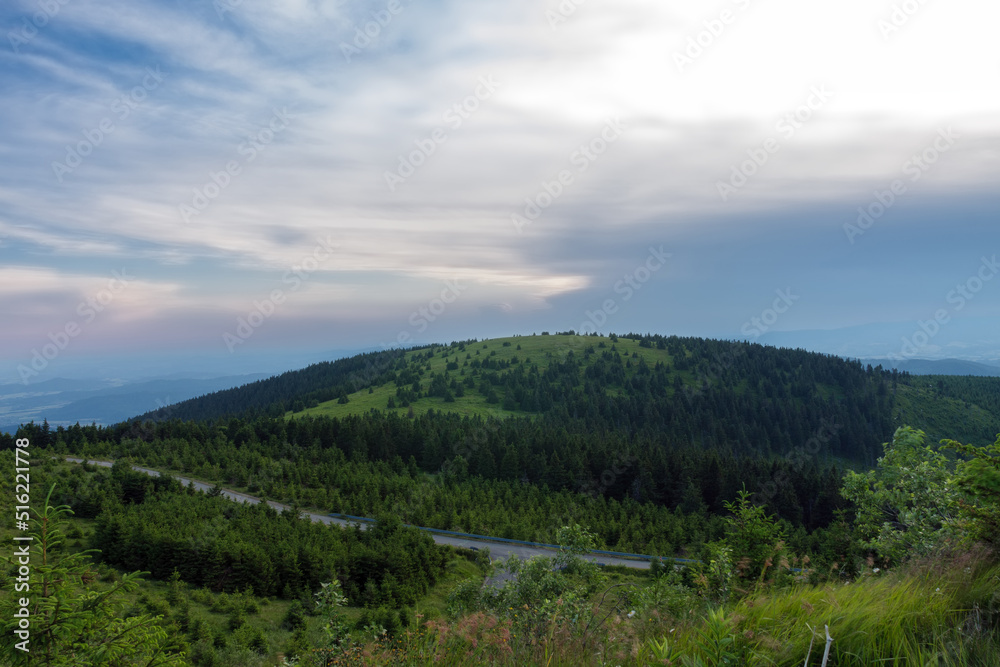 Fototapeta premium Mravenecnik hill , view from upper water reservoir of the pumped storage hydro power plant Dlouhe Strane in Jeseniky Mountains, Czech Republic. During summer evening, sunset with blue sky and clouds.