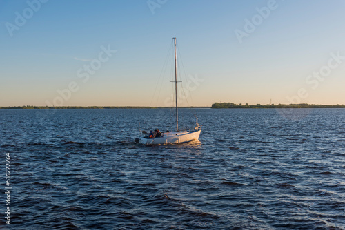 yacht on the Severnaya Dvina River on a summer evening against the background of distant shores.