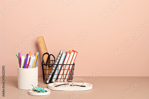 Desktop organizer with school stationary and office supplies over pastel background. Back to school, home office, begining of studies concept photo