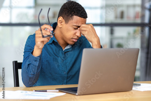 Φωτογραφία Portrait of tired stressed African American man having headache feeling sick, ti