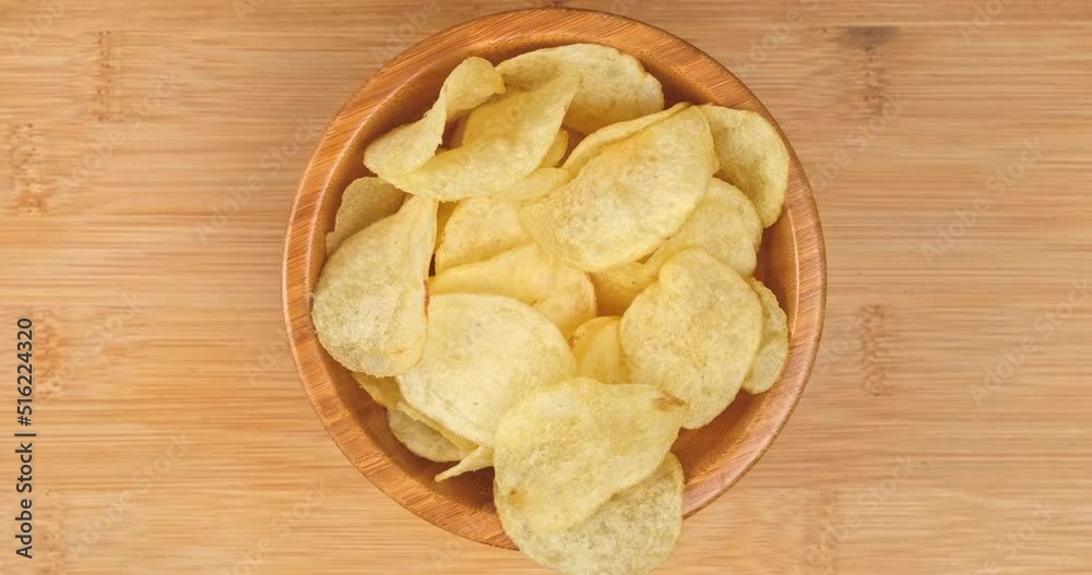 4k video, craft fried golden potato chips, top view and close up. many people used hands eating potato chips from a wooden plate. fast food background 4k video, craft fried golden potato chips, top view and close up. many people used hands eating potato chips from a wooden plate. fast food background