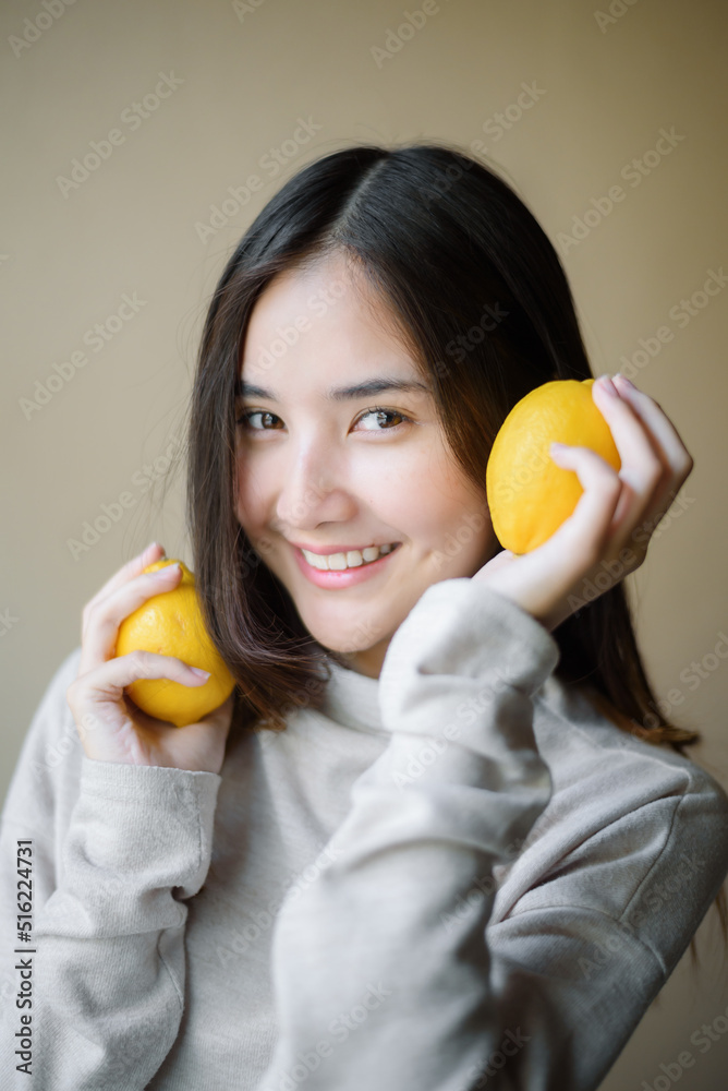 attractive cheerful asian woman holding yellow lemon, beauty and healthy skin care and cosmetic ideas concept attractive cheerful asian woman holding yellow lemon, beauty and healthy skin care and cosmetic ideas concept