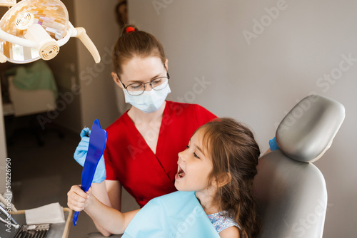 Children dentistry. Dentist and child patient. Consultation with child dentist at dentistry. Teeth treatment. Child looking in the mirror at the dentist. Happy child patient of dentistry.