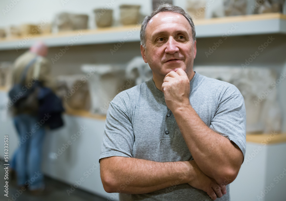 Naklejka premium Portrait of senior man visiting museum of ancient sculpture