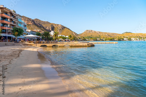 Fototapeta Naklejka Na Ścianę i Meble -  The beach and promenade with the piers of Port de Pollença in the evening at sunset.