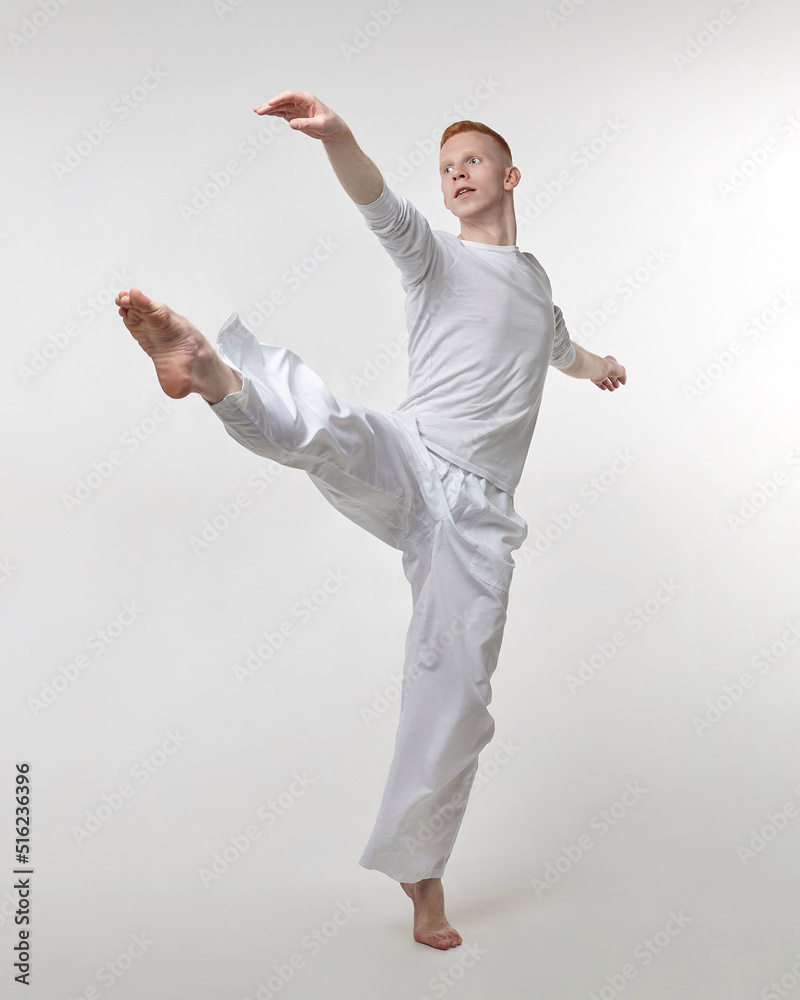red-haired male dancer demonstrates the choreographic elements of the dance. photo shoot in the studio on a white background red-haired male dancer demonstrates the choreographic elements of the dance. photo shoot in the studio on a white background