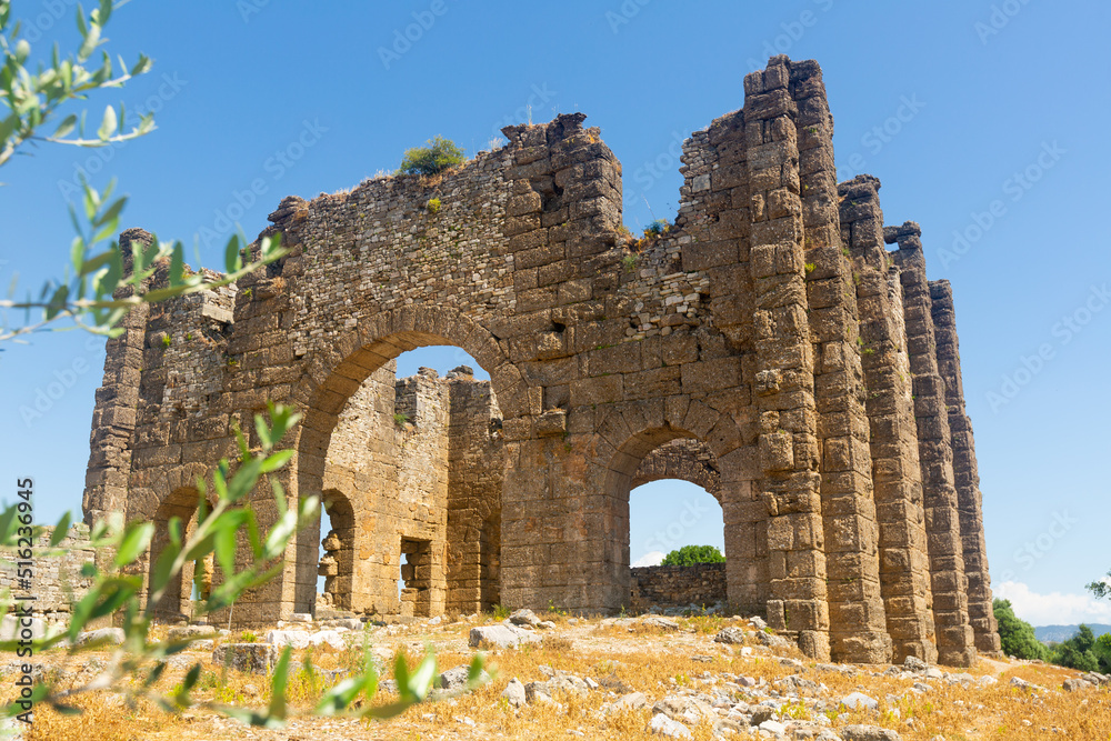 Surviving remains of ancient basilica in Aspendos city. View of eastern section of stone building with arched openings on sunny spring day, Antalya province, Turkey