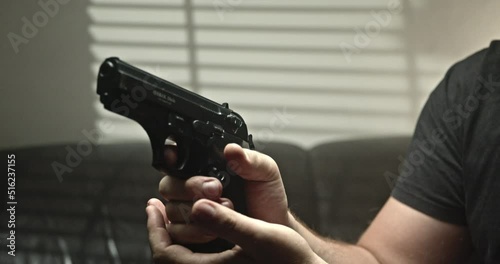 a man puts a magazine in a gun