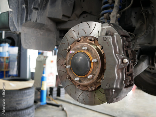 maintaining car wheel brake disc at repair service station.