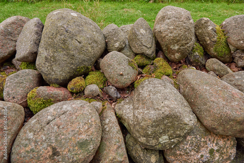 Closeup of a stone wall made of boulders and rocks outside. Background of rustic, rural building and masonry material. Historic housing design or antique architecture of an urban structure outdoors Closeup of a stone wall made of boulders and rocks outside. Background of rustic, rural building and masonry material. Historic housing design or antique architecture of an urban structure outdoors