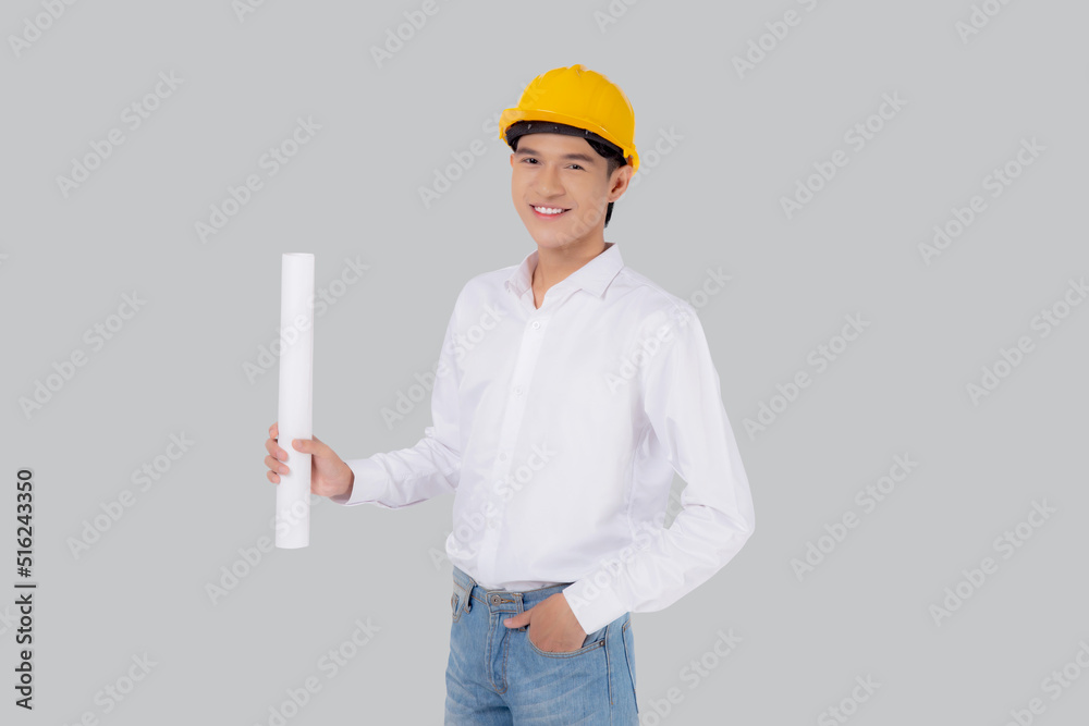 Portrait young asian man is engineer wearing helmet standing and holding blueprint with confident isolated on white background, handsome male is architect or contractor, worker or labor concept. Portrait young asian man is engineer wearing helmet standing and holding blueprint with confident isolated on white background, handsome male is architect or contractor, worker or labor concept.