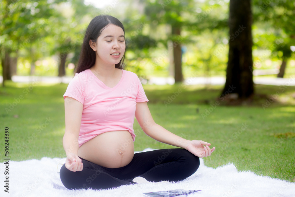 Happiness young asian woman pregnant sitting doing yoga with meditation lotus for relaxation in the park, mother practicing workout for health in the garden, exercise or sport for pregnancy concept. Happiness young asian woman pregnant sitting doing yoga with meditation lotus for relaxation in the park, mother practicing workout for health in the garden, exercise or sport for pregnancy concept.