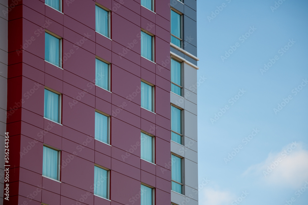 The exterior wall of a contemporary commercial style building with aluminum metal composite panels and glass windows. The futuristic building has engineered diagonal cladding steel frame panels. The exterior wall of a contemporary commercial style building with aluminum metal composite panels and glass windows. The futuristic building has engineered diagonal cladding steel frame panels.