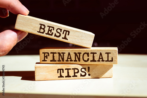 Best financial tips symbol. Businessman hand. Wooden blocks with words 'Best financial tips'.