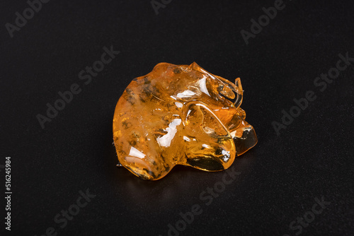 golden dab of cannabis on a dark background, high thc wax extract. photo