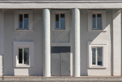 House wall texture with columns and windows with door on a summer sunny day © Elmir