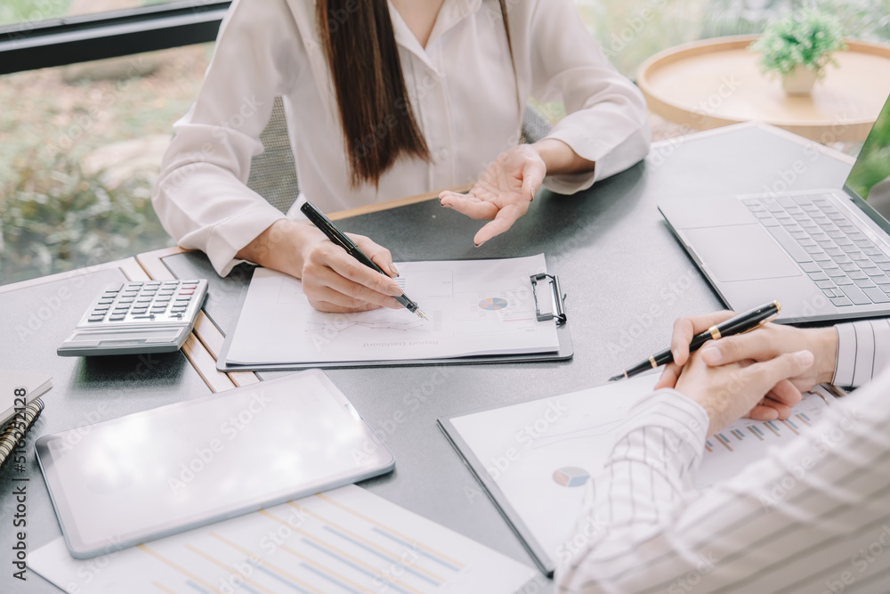 Marketer or analytic manager team dressed in suits working with paper charts and laptops at the meeting room. Marketer or analytic manager team dressed in suits working with paper charts and laptops at the meeting room.