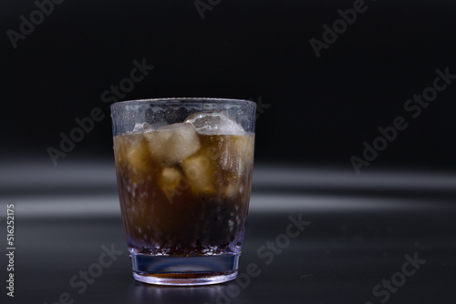 Soda and ice in a clear plastic cup.
