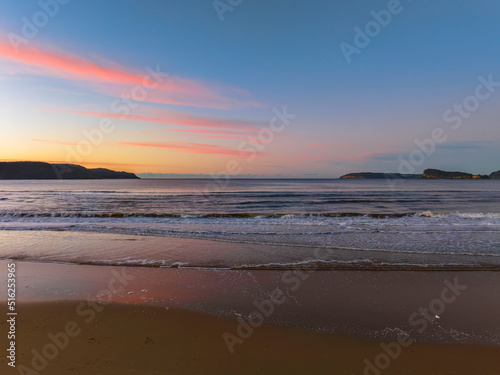 Gentle sunrise seascape with light scattered high cloud