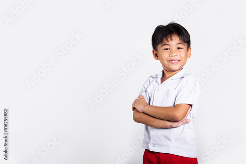 Asian toddler smile happy wearing student thai uniform red pants stand with arms folded in studio shot isolated on white background, Portrait little children boy preschool crossed arms, Back to school