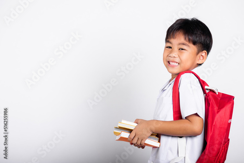 Asian adorable toddler smiling happy wearing student thai uniform red pants stand books for study ready for school isolated on white background, Portrait little children boy preschool, Back to school