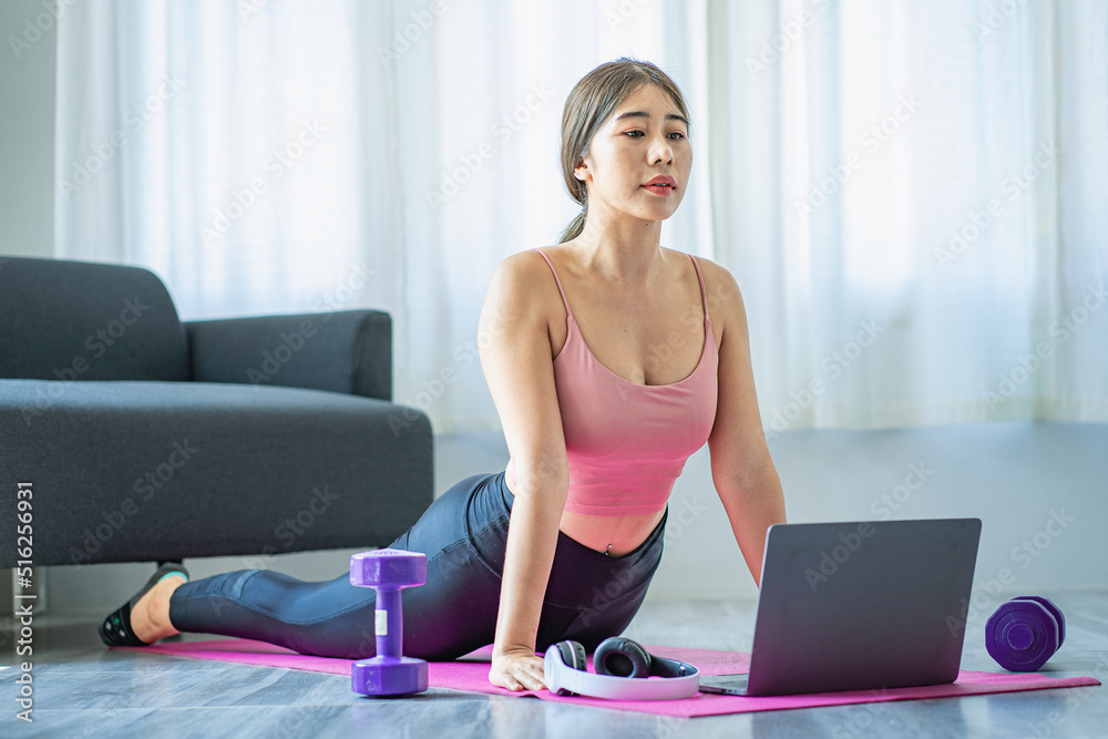 Asian woman doing shoulder stretching yoga at home in living room, fitness fit yoga for good health. Asian woman doing shoulder stretching yoga at home in living room, fitness fit yoga for good health.