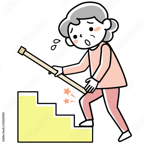 手すりにつかまって階段を上るシニア女性