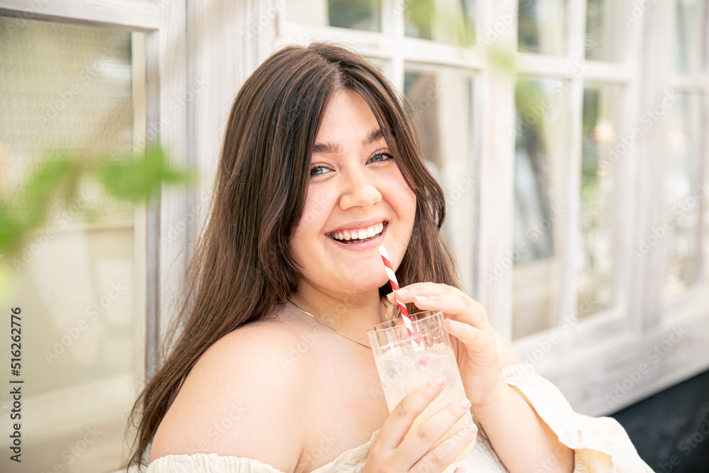Attractive young woman with a glass of lemonade on the cafe terrace. Attractive young woman with a glass of lemonade on the cafe terrace.