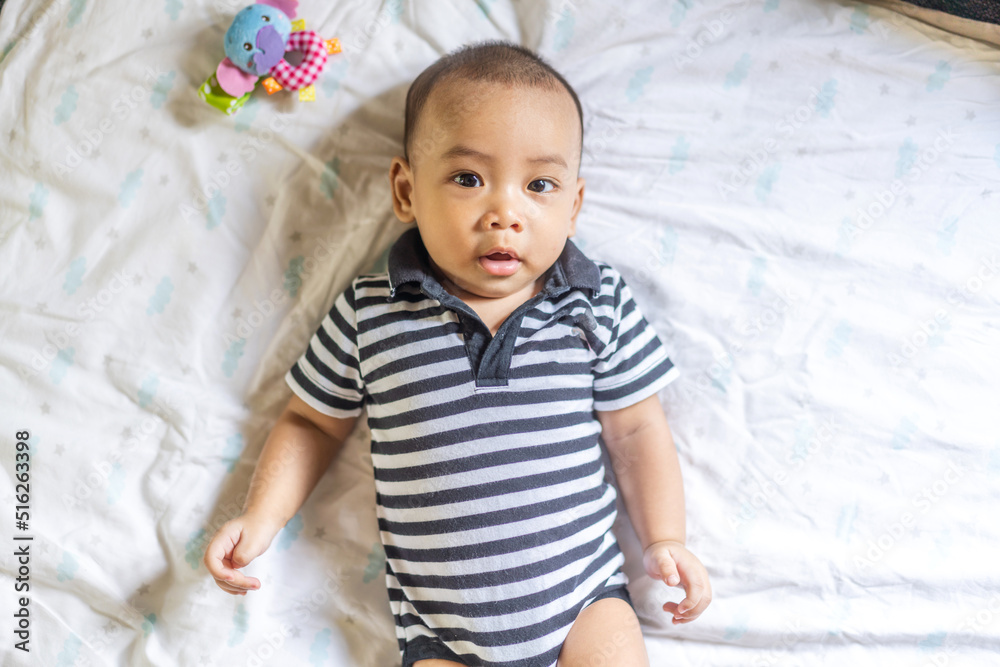 Portrait of happy smile asian baby boy relaxing looking at camera.Cute asian newborn child on the bed at home Portrait of happy smile asian baby boy relaxing looking at camera.Cute asian newborn child on the bed at home