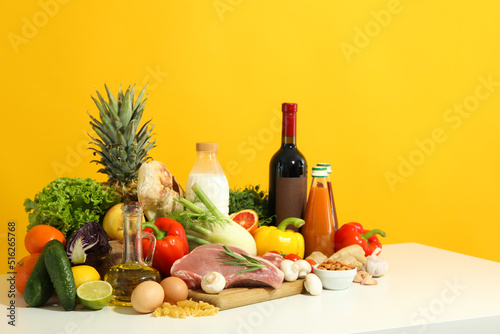 Fototapeta Naklejka Na Ścianę i Meble -  Group of different grocery on white table against yellow background
