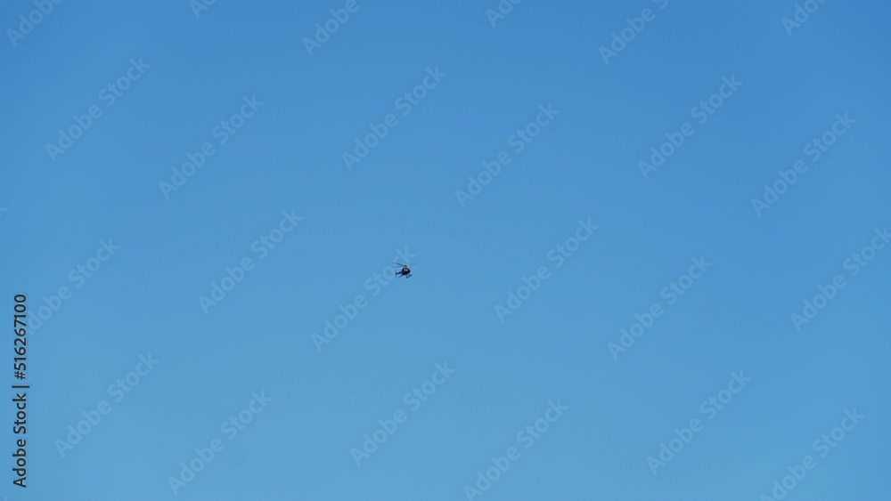 Wide Bottom Up View of a Helicopter Flies Through the Blue Sky on a Bright Day Wide Bottom Up View of a Helicopter Flies Through the Blue Sky on a Bright Day