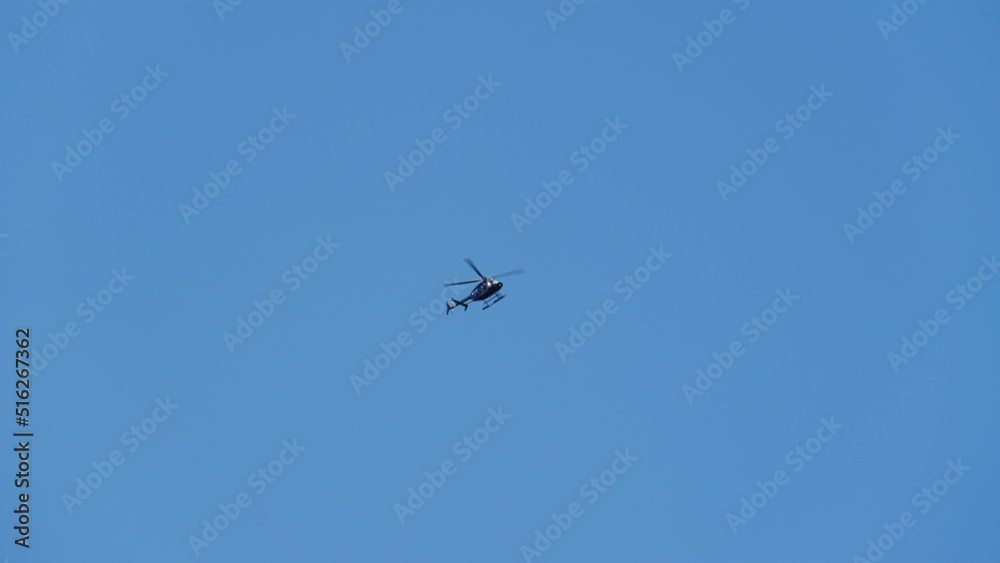 Wide Bottom Up View of a Helicopter Flies Through the Blue Sky on a Bright Day Wide Bottom Up View of a Helicopter Flies Through the Blue Sky on a Bright Day