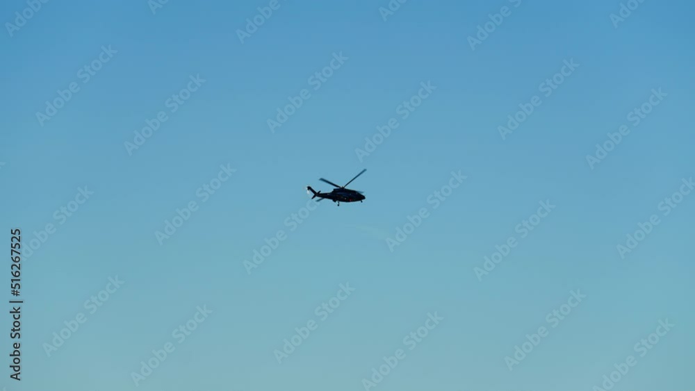 Bottom Up View of a Helicopter Climbing Up in the Blue Sky on a Bright Day Bottom Up View of a Helicopter Climbing Up in the Blue Sky on a Bright Day