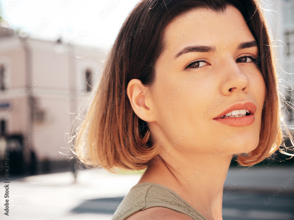 Closeup portrait of young beautiful smiling hipster woman in trendy summer clothes. Sexy carefree model posing on the street background at sunset. Positive brunette female. Cheerful and happy