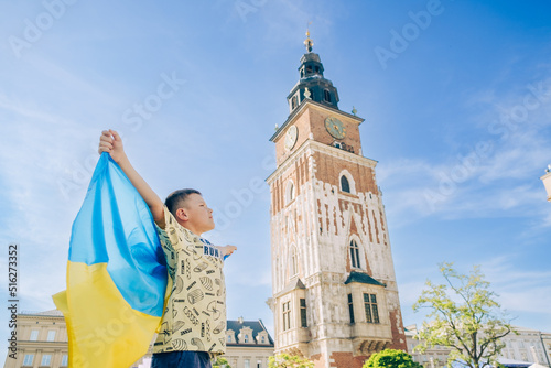 little boy holding ukrainian flag at Krakow Poland town