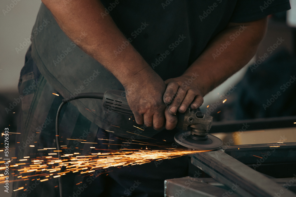 Close up on a man held an angle grinder to cut an iron with sparks