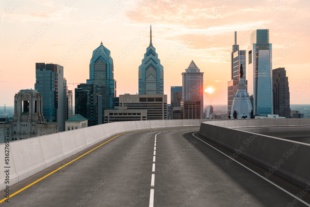 Empty urban asphalt road exterior with city buildings background. New modern highway concrete construction. Concept way to success. Transportation logistic industry fast delivery. Philadelphia. USA.