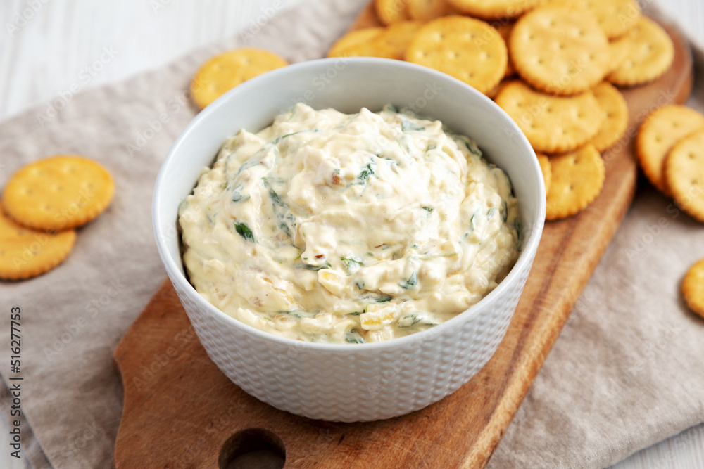 Homemade Caramelized Onion and Spinach Dip with Salty Round Crackers, side view. Close-up. Homemade Caramelized Onion and Spinach Dip with Salty Round Crackers, side view. Close-up.