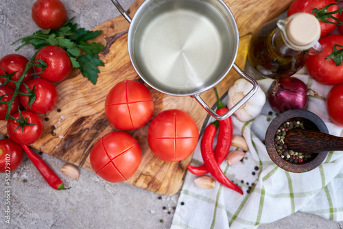 Photos blanched tomatoes on wooden cutting board ready for peeling at domestic kitchen