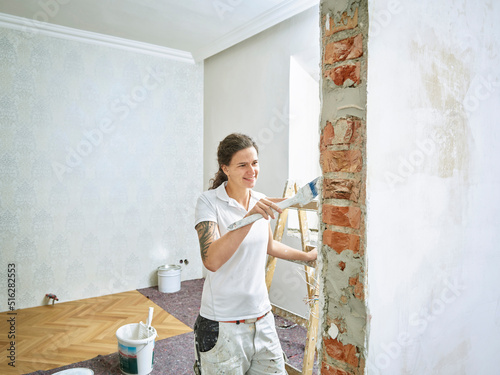 Happy painter painting doing final painting in apartment photo