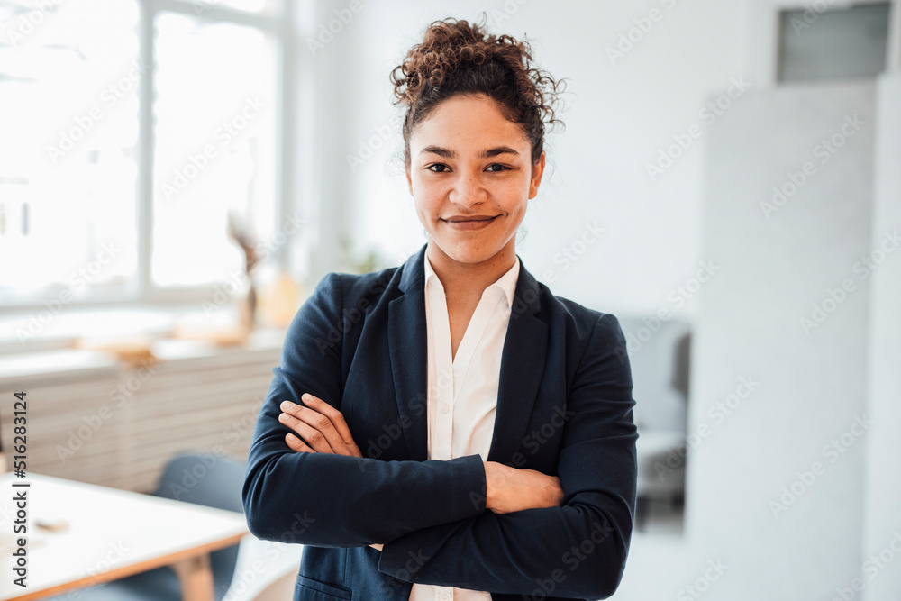 Smiling businesswoman with arms crossed standing in office Smiling businesswoman with arms crossed standing in office